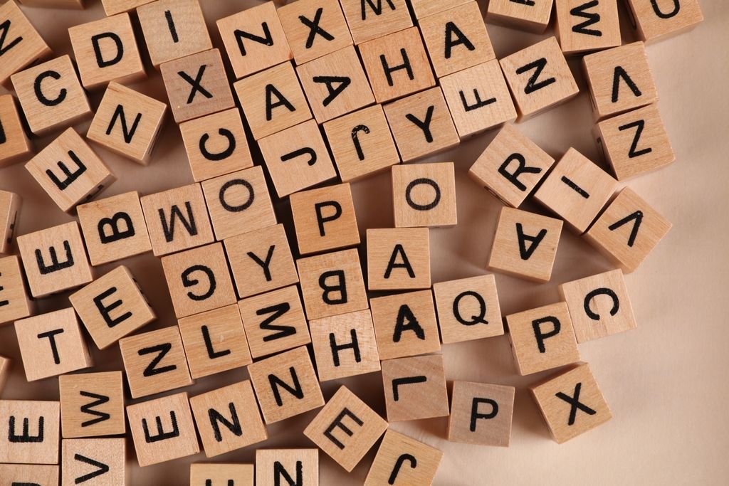 Close-up of scattered wooden alphabet blocks, ideal for educational and playful themes.