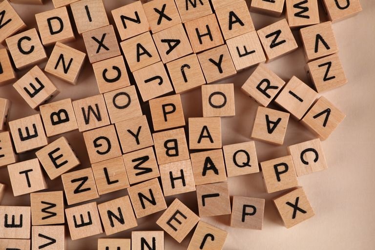 Close-up of scattered wooden alphabet blocks, ideal for educational and playful themes.