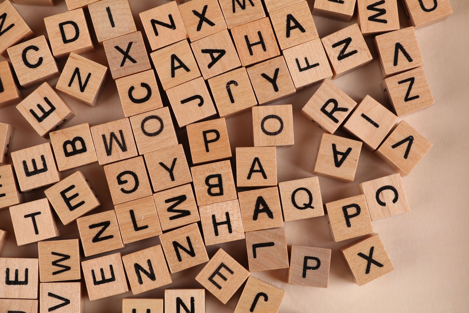 Close-up of scattered wooden alphabet blocks, ideal for educational and playful themes.